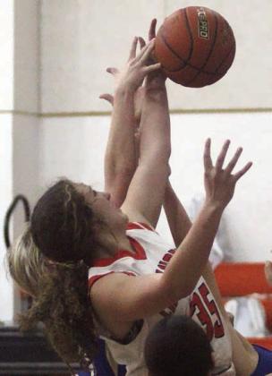 Grace Schramek goes up for an offensive rebound against Louise. Sticker Photo By Darrell Vyvjala