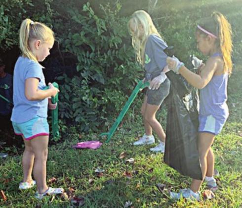 Chandler Bubela (front, left), Ella Banse (front, right), and Brynn Bubela help pick up trash as part of Keep Schulenburg Beautiful’s Fall Sweep.