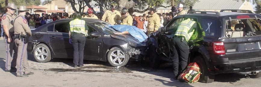 DPS troopers, EMS personnel, and firefighters work the mock accident scene as high school students look. Sticker Photo By Darrell Vyvjala