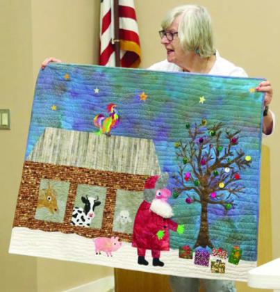 RIGHT PHOTO – Brigitte Wittmann Mesecke shows her quilt which features a picture out of the children’s book Dream Snow.