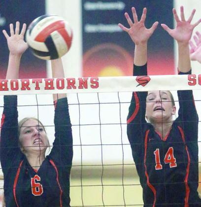 Clara Magliolo (left) and Emmrie Marx go up for a block against the Lady Bulldogs. Sticker Photo By Darrell Vyvjala