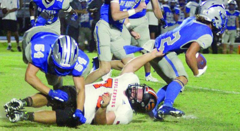 Marshall Wellborn holds up Cody Howard in the backfield long enough to allow his teammates to make a stop for a loss of 1 in the third quarter. Sticker Photo By Darrell Vyvjala