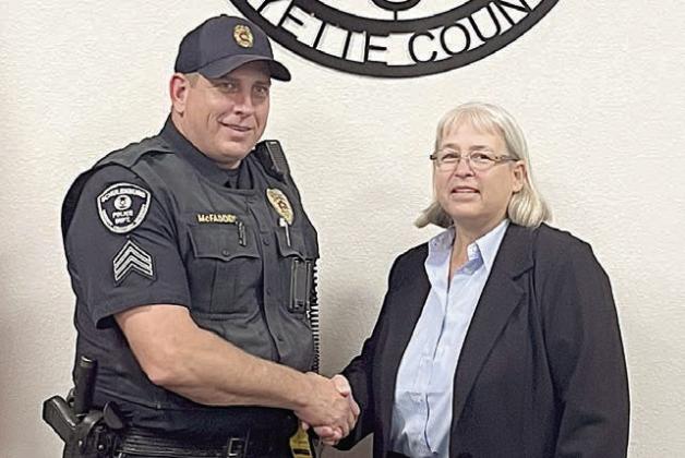 Mayor Connie Koopmann (right) congratulates Sgt. Tobey McFadden on his 10-year anniversary with the City of Schulenburg during Monday night’s City Council meeting. She and the aldermen expressed their appreciation for McFadden’s service to the community. Sticker Photo By Layne Vyvjala