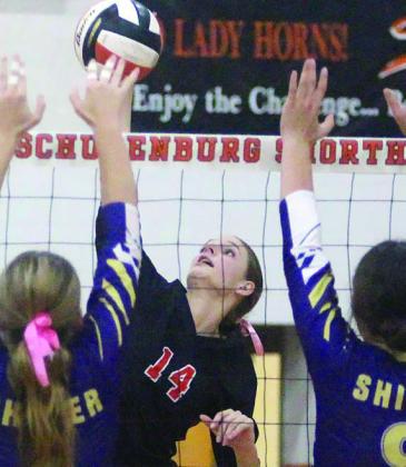 Emmrie Marx connects for a kill past a pair of Shiner blockers in game three. Sticker Photo By Darrell Vyvjala
