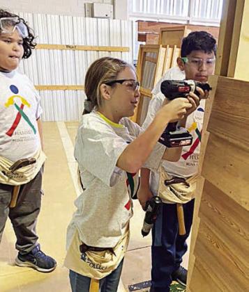 Building a house large enough to contain all HammerBuild camp participants provides a learning experience that involves math, teamwork, using tools, etc. Students are shown using drills during the process at a previous ‘Hammer’ event.