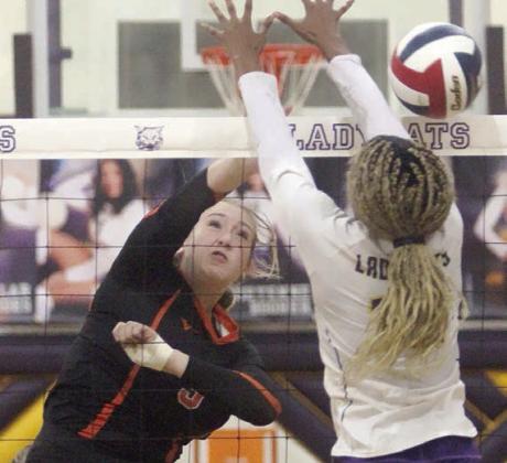 Reagan Dusek smashes a kill past a Ladycat block attempt in the fourth set. Sticker Photo By Darrell Vyvjala