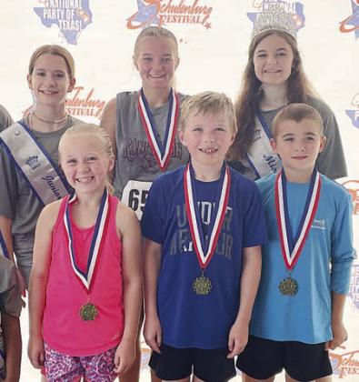 One-mile winners – (front, from left) Hannah McGee of Fulshar, 9 &amp;amp; under female; Luke Walsh of Katy, 9 &amp;amp; under male; Gage Smrkovsky of Schulenburg, 10 &amp;amp; over male; and (back, center) Natalie Ohnheiser of Weimar, 10 &amp;amp; over female. Also pictured are Miss Schulenburg Riley Zapalac (back, right) and Junior Miss First Runner-Up Kylee Hoffmann. Sticker Photo By Darrell Vyvjala