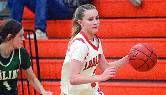 Jenna Guentert dribbles past a Luling defender at midcourt. Sticker Photo By Darrell Vyvjala