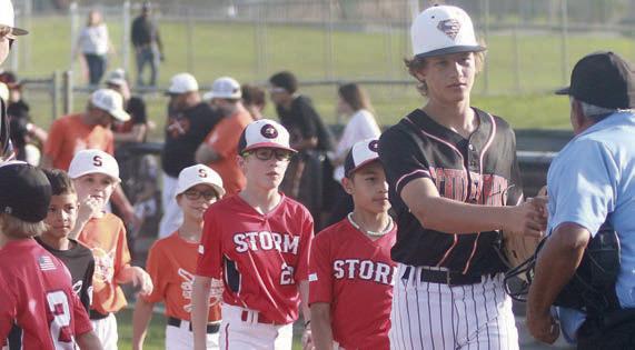 A group of youngsters follow Brayden Stoever during pre-game introductions last Tuesday as part of the Shorthorns’ recognition of youth baseball and softball players. Sticker Photo By Darrell Vyvjala