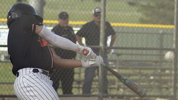 Landon Conner connects for a sacrifice fly to drive in a run against Bloomington. Sticker Photo By Darrell Vyvjala