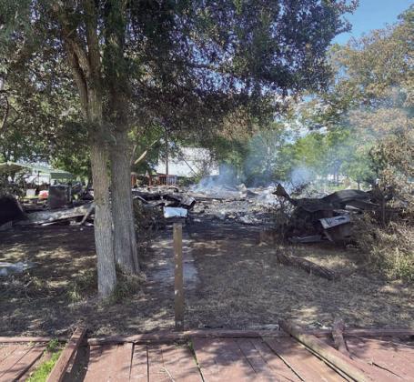 These photos, submitted by Betty Danner of Cistern, show the two-story home fully engulfed (at left) and in rubble on the ground after the fire (at right). The street sign in the foreground of the left photo says St. Charles St., which is located in Cistern.