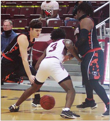 Brett Janecek (left) and T. J. Speed (right) double-team Cadarian Wiley near midcourt in the first quarter. Sticker Photo By Kade Vyvjala