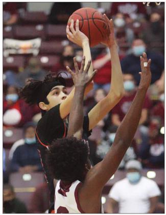 Alex Lozano gets a bucket after an offensive rebound in the first quarter.  Sticker Photo By Kade Vyvjala