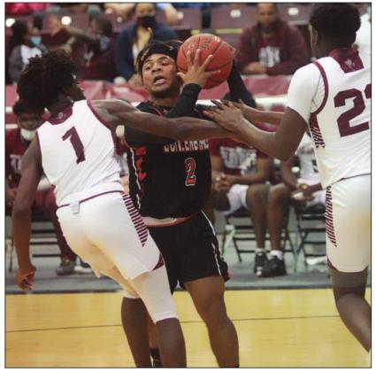 Keisean Johnson battles two Grapeland defenders to keep possession of the ball. Sticker Photo By Kade Vyvjala