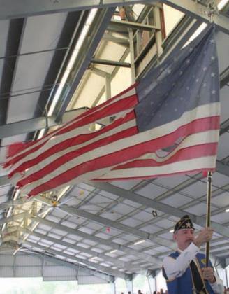 American Legion McBride Post 143 First Vice Commander Ed Semler waves a tattered flag while the song “Ragged Old Flag” by Johnny Cash is played. Sticker Photo By Darrell Vyvjala