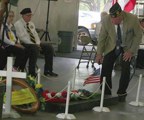 American Legion McBride Post 143 Commander Bob Heinrich places a flag on the “Grave of the Unknown Soldier.” Sticker Photo By Darrell Vyvjala