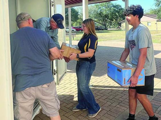 (from left) Jack Niesner and Ken Berger from the SAFP and NHS members Kyrroll Prihoda and Edgar Mandujano load boxes of items from the food drive into the trailer.