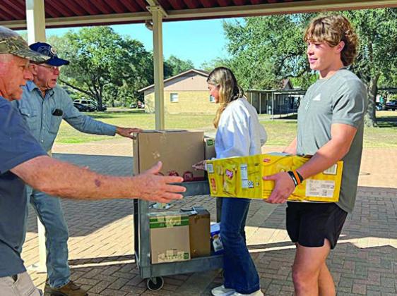 (from left) Jack Niesner and Ken Berger from the SAFP and NHS members Klare Segura and Jayse Janda load the trailer with boxes from the food drive.