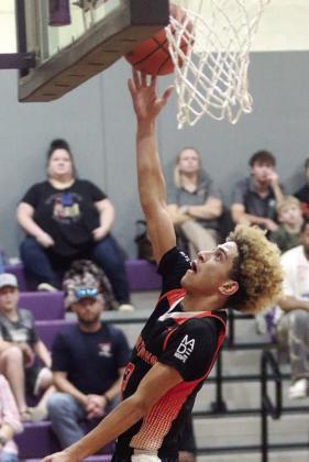Denver Carr scores on a fast-break layup in the third quarter at Weimar. Sticker Photo By Darrell Vyvjala