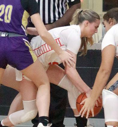 Jenna Guentert secures a loose ball after a Lady Comanche missed shot late in the fourth quarter. Sticker Photo By Darrell Vyvjala