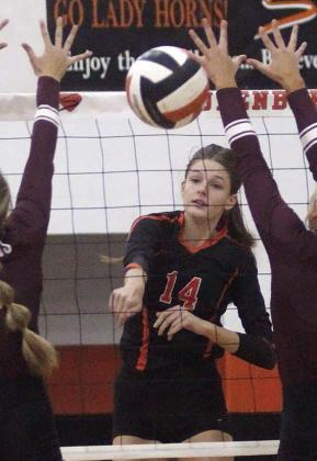 Emmrie Marx fires down one of her 17 kills Friday in between two blockers. Sticker Photo By Darrell Vyvjala