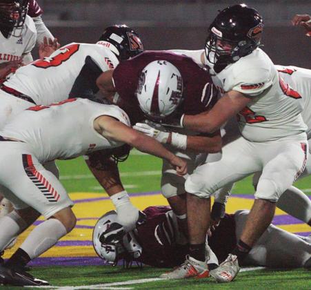 Hayden Schulz (right), Evan Oeding (front, left), and Rodney Walton combine to corral Owen Espinoza for a loss of 1 in the third quarter. Sticker Photo By Layne Vyvjala
