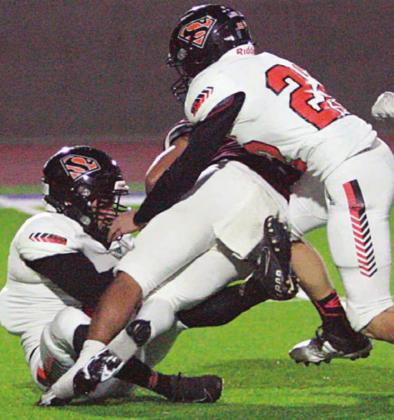 Trent Mendez (left) and John Davis combine to hold Daniel Pena to a 7-yard kickoff return in the first quarter. Sticker Photo By Layne Vyvjala