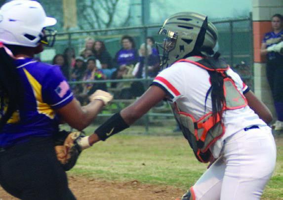 Catcher Jashiya Jackson tags out a Ladycat before she touches home plate. Sticker Photo By Darrell Vyvjala
