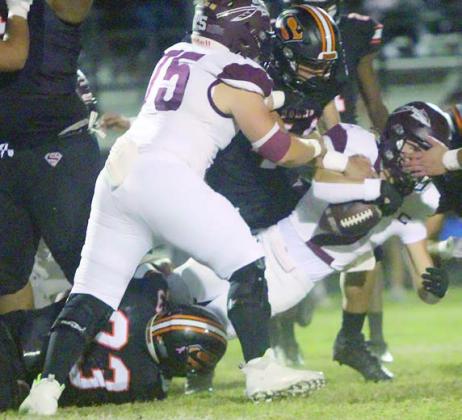 Jayvan Luhrs (below) brings down Logan Bures for a short gain in the first quarter with help from Aidan Mendez. Sticker Photo By Layne Vyvjala