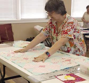 Piecing finished blocks for the “Poppy Quilts” is Kathi Babcock.