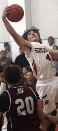 Jayse Janda snags an offensive rebound in the first quarter against Ganado. Sticker Photo By Darrell Vyvjala
