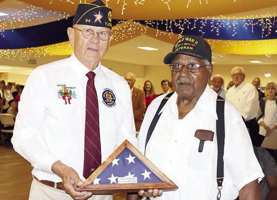 The oldest veteran in attendance, 101-year-old World War II veteran B.J. Anderson of Smithville (right), is presented a folded flag by Flatonia American Legion Commander Danny Vyvjala (left). Photo By Melanie Berger / Courtesy of Flatonia Argus