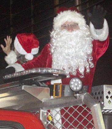 SANTA &amp; MRS. CLAUS arrive in town via a Schulenburg Volunteer Fire Department truck as part of the Lighted Christmas Parade later in the evening. Sticker Photo By Darrell Vyvjala