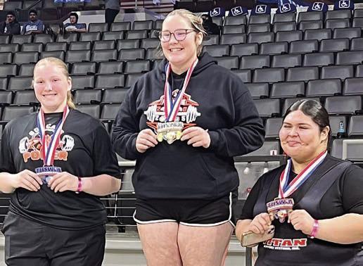 Cora Brenek (center) stands atop the medal stand following her statequalifying performance at the regional meet.