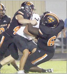 Rogerick H Walton (right) gets help from Jacob Vacek to stop Abraham Hernandez for no gain in the third quarter. Sticker Photo By Layne Vyvjala