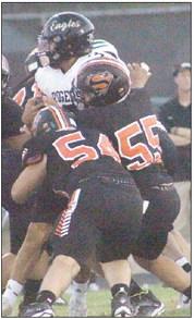 Dean Bradley (No. 55) and Tyson Wagner stack up Cooper Sisneroz after a short gain in the first quarter. Sticker Photo By Layne Vyvjala