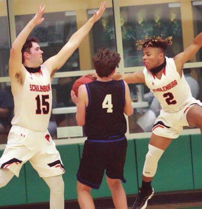 Keisean Johnson (right) and Brett Janecek defend Conner Kreutziger’s shot attempt in the second half. Sticker Photo By Layne Vyvjala