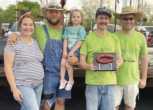 “SWINGIN’ LINKS” – 2ND PLACE SMOKED SAUSAGE / PEOPLE’S CHOICE – (from left) Morgan and Colton Bubela (holding daughter, Martha Clare), Jacob Valenta, and Clayton Weishuhn. Not shown: Mary and Fritz Valenta. Sticker Photo By Darrell Vyvjala