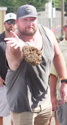 Sean McCourt releases a winning toss in the Cow Chip contest Saturday. Sticker Photo By Darrell Vyvjala