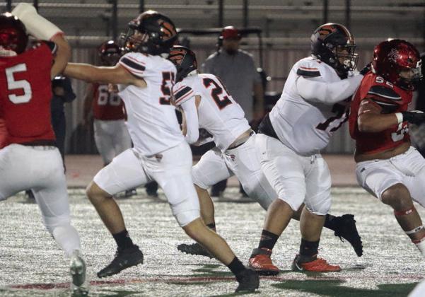 Dean Bradley (left) and Calvin Thompson (right) clear the way for Mason Kunschick on a 12-yard run in the first quarter. Sticker Photo By Layne Vyvjala