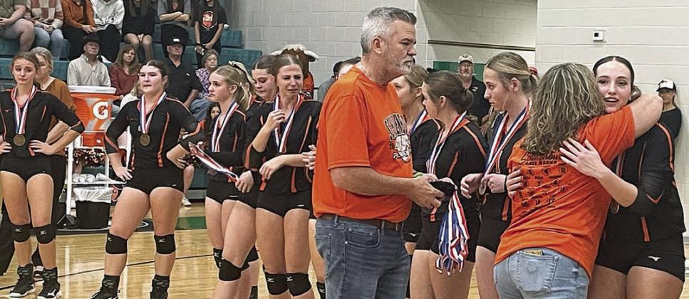 Grace Schramek (right) gets a hug from High School Principal Callene Zapalac as she and Superintendent Lee Hafley hand out bronze medals to the Lady Horns. Sticker Photo By Darrell Vyvjala