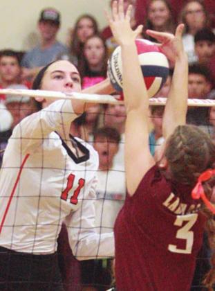 Meredith Magliolo knocks down a kill in the first set off the block attempt of Natalie Newton. Sticker Photo By Darrell Vyvjala