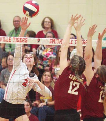 Claire Antosh sends an attack past a pair of Thorndale blockers in the first set. Sticker Photo By Darrell Vyvjala