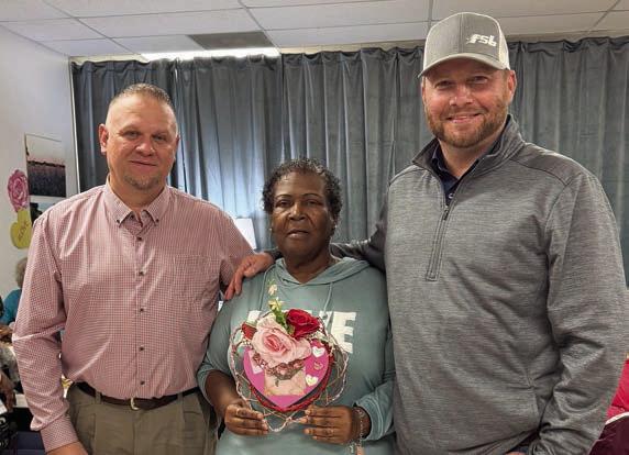 Bingo – Members have extra fun when Precinct 4 County Commissioner Drew Brossmann (right) joins them for bingo. He brought along Paul Zapalac (left), Precinct 4 Justice of the Peace, on his most recent visit. Alfreda Ellison (center) holds the blackout prize, created by Martha Beckmann, and had to win two playoffs to secure this Valentine’s creation.