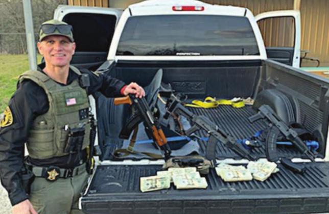Investigator David Smith with weapons and U.S. currency that were confiscated after he stopped a 2006 Chevrolet pickup on Interstate 10 near Flatonia on Thursday, Jan. 28.