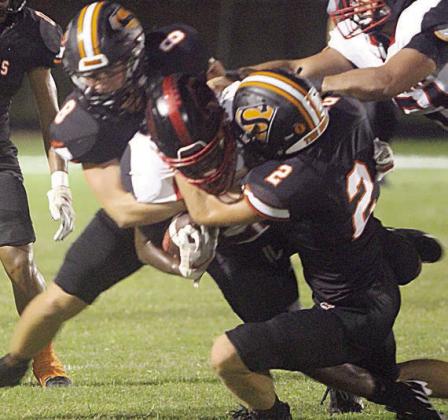 John Davis (No. 2) and Owen Brenek combine to take down Carter Morrison late in the first quarter. Sticker Photo By Layne Vyvjala