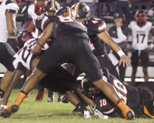 Tavondrick Ellison (No. 10) makes a tackle in the first quarter with help from Jayvan Luhrs (front) and Aidan Mendez (No. 44). Sticker Photo By Layne Vyvjala
