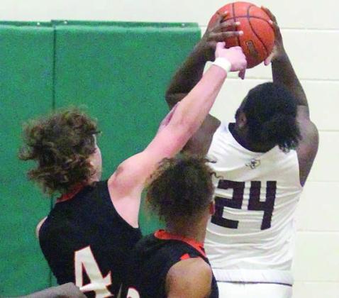 Aaron Janecek gets a piece of Jimmie Jones’ shot in the second quarter. Sticker Photo By Darrell Vyvjala