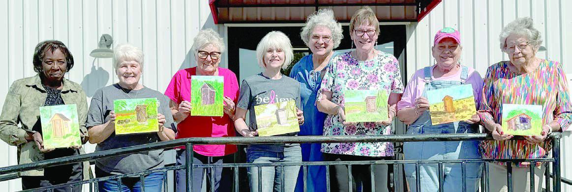 Artful Friday students (from left) Deborah Jones, Betty Mulholland, Sandy True, Kim Penland, teacher Sue Pape, Berni Gillings, Annette Jasek and Irene Janda showing off their outhouse paintings from October classes.