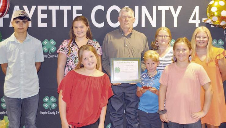 Friend oF 4-H – Melvin Schulze (back center, holding certificate). He is shown with Winchester 4-H Club members (front row, from left) Ambri Gooch, Grant Fryer, Saydee Hart, (back row) Grayson Hart, Raynee Hart, (continuing after Schulze) Blair Gooch and Addison Fryer.